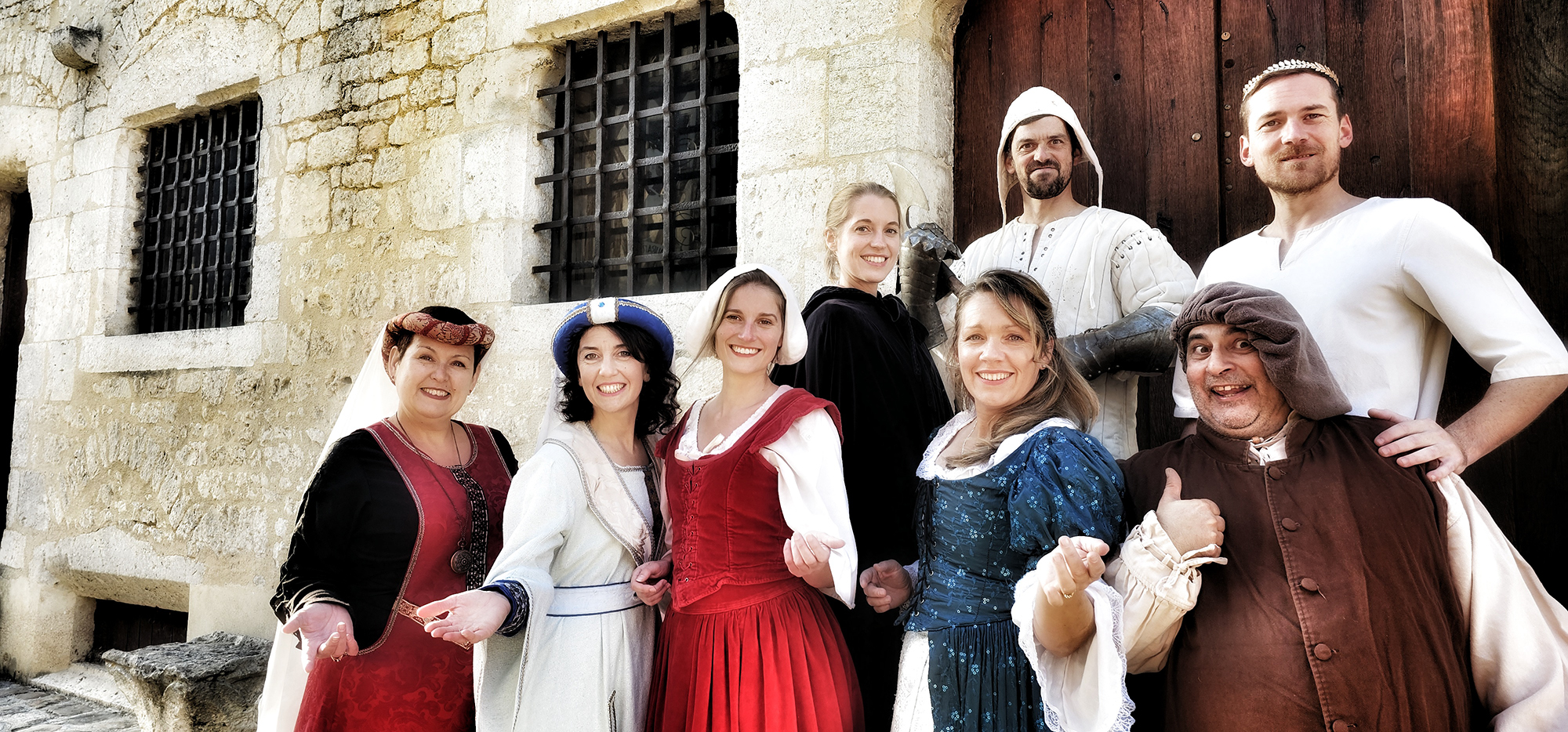 Cinq femmes et trois hommes costumés dans le thème médiévale.