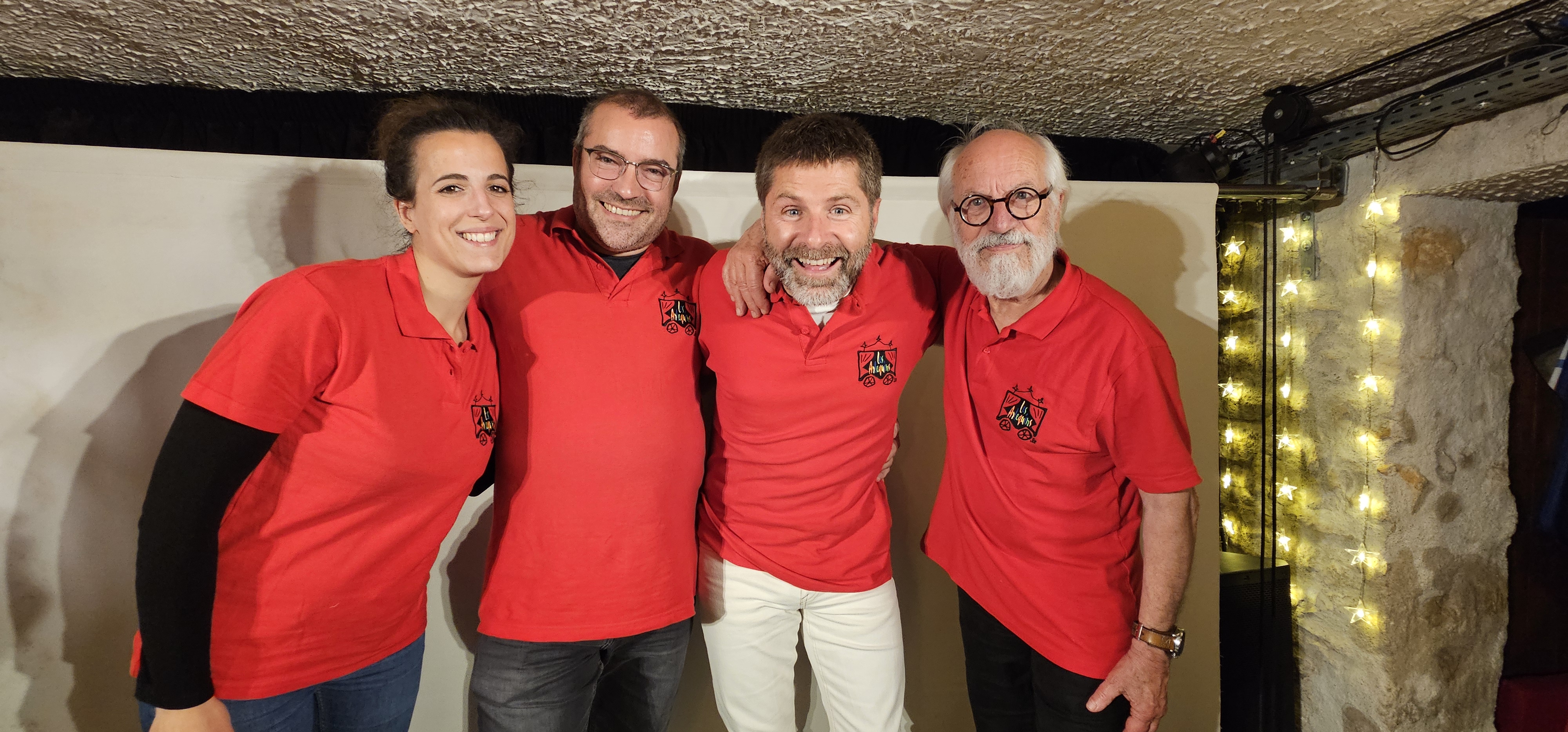 Une femme et trois hommes s'enlaçant et souriant à l'objectif de la caméra. Ces personnes portent un polo rouge avec le logotypes Les Arlequins. Il s'agit des membres du bureau de la compagnie.