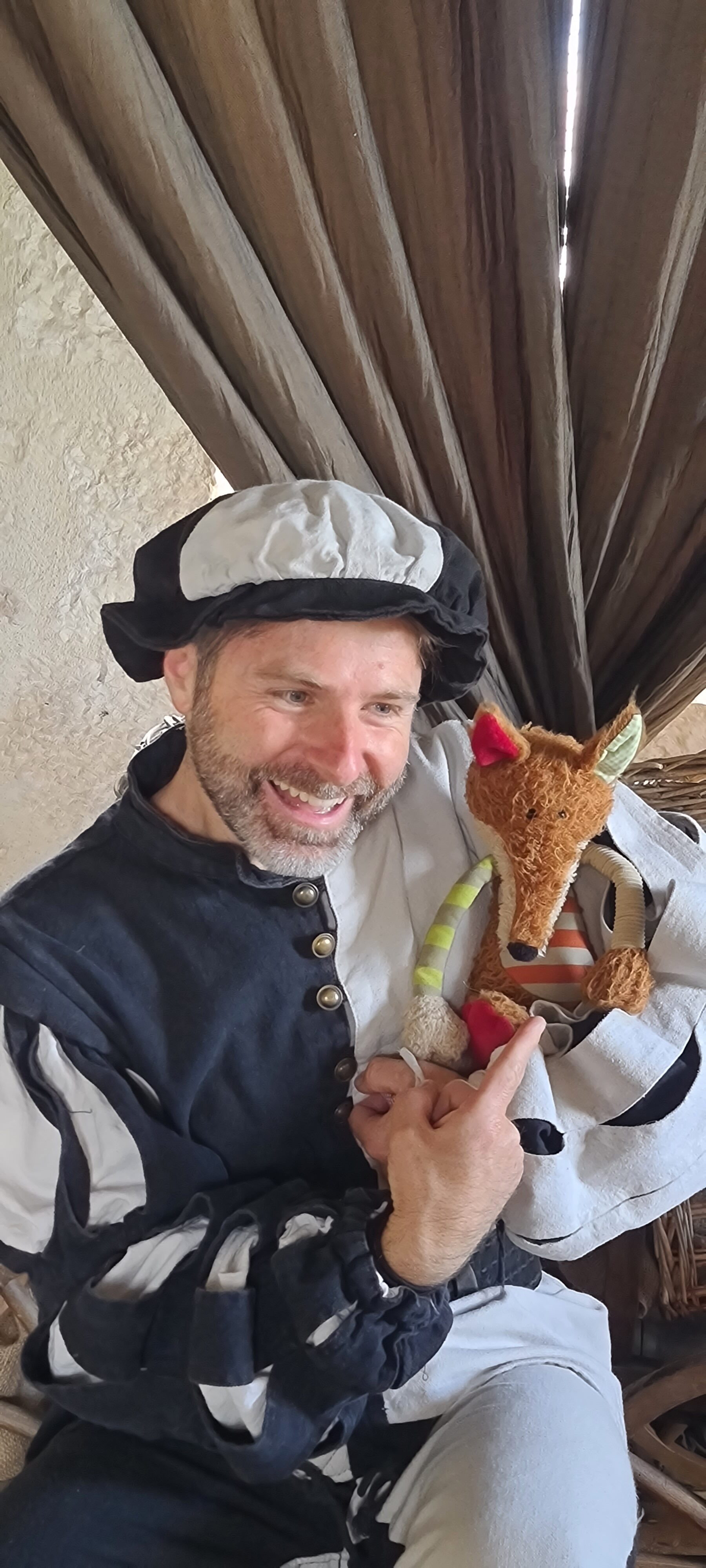 Portrait d'un comédien avec une peluche de Renart dans les bras.