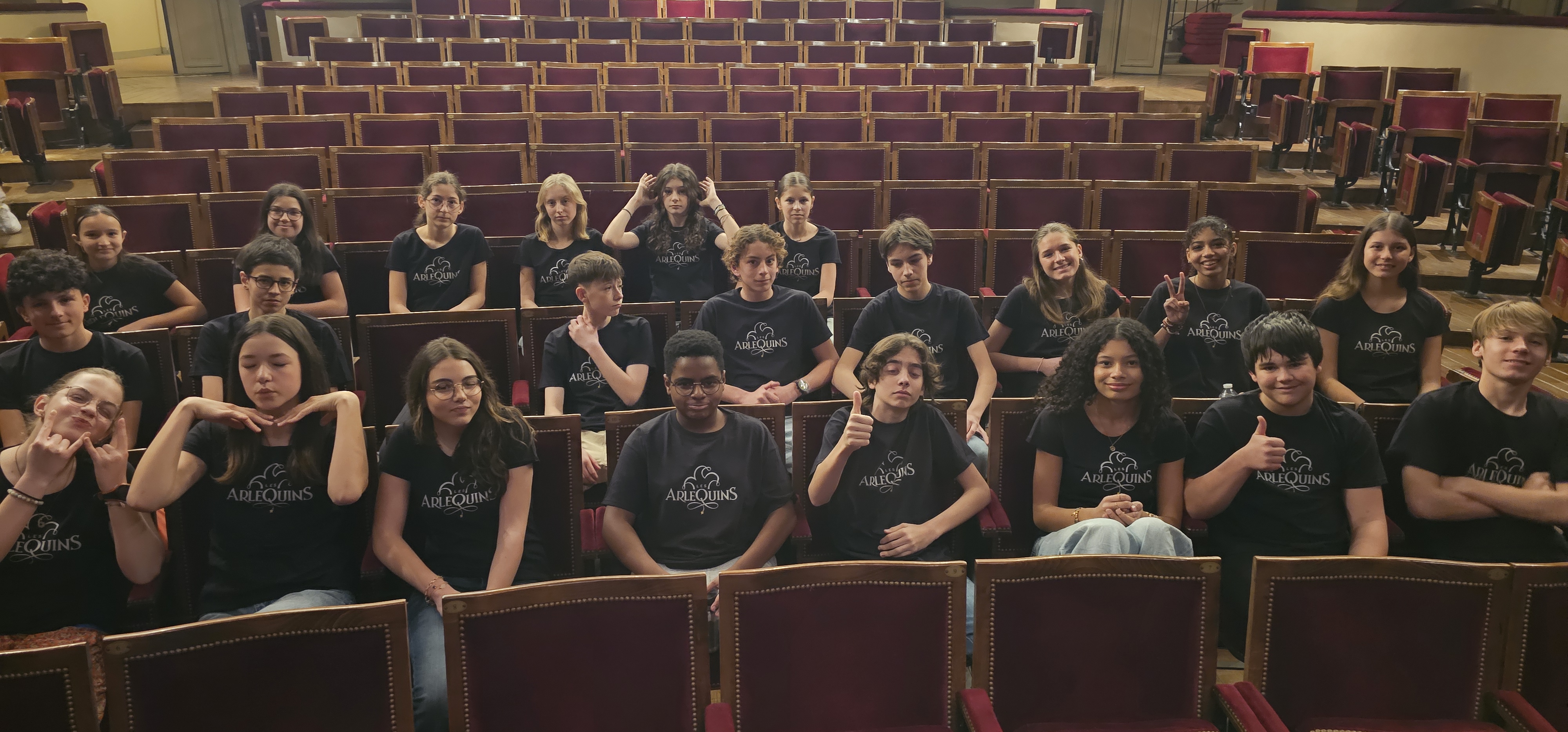 Groupe d'adolescents installé dans le public d'une salle de théâtre.