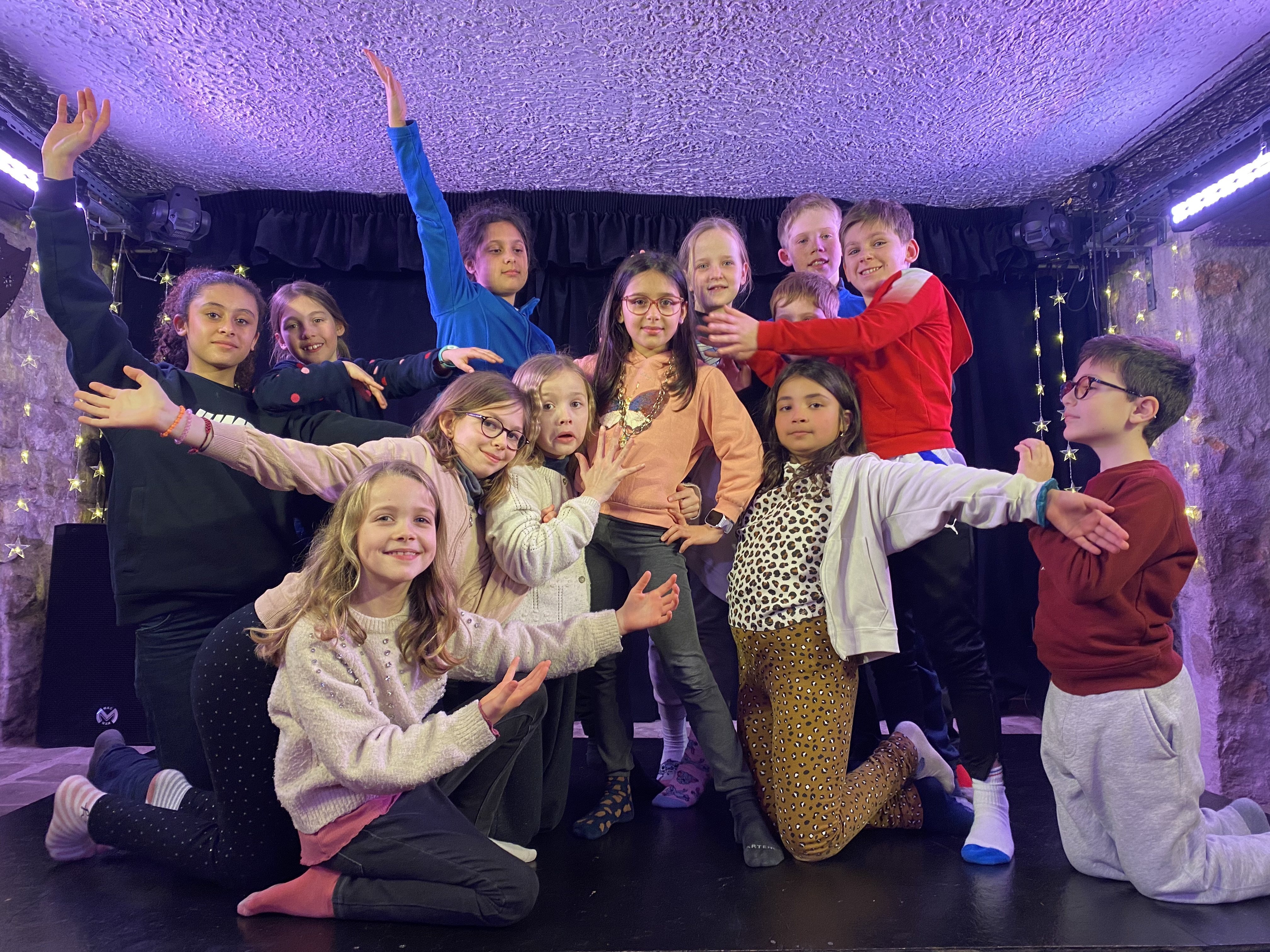 Groupe d'enfants sur une scène de théâtre.