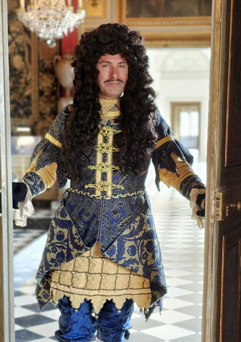 Un homme costumé ouvrant une porte.